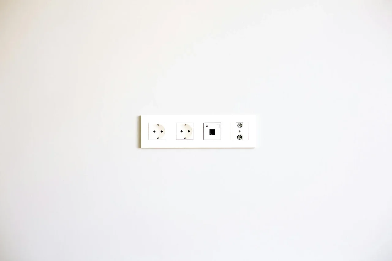 protección niños electrodomésticos: niño junto a enchufe con protector