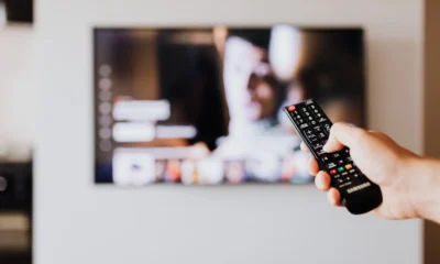 Imagen para conectar auriculares bluetooth a televisor en un salón moderno con una persona emparejando los cascos inalámbricos con la Smart TV.