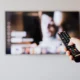 Imagen para conectar auriculares bluetooth a televisor en un salón moderno con una persona emparejando los cascos inalámbricos con la Smart TV.