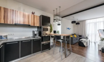 Cocina abierta al salón moderna con una persona cargando un lavavajillas integrado; imagen representativa para Lavavajillas silencioso para cocina abierta al salón: guía de compra.