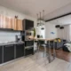 Cocina abierta al salón moderna con una persona cargando un lavavajillas integrado; imagen representativa para Lavavajillas silencioso para cocina abierta al salón: guía de compra.