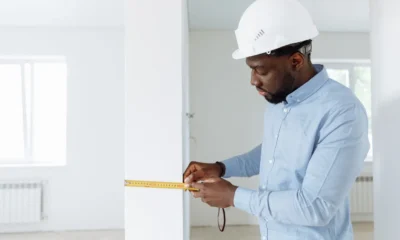 Persona midiendo el hueco para un frigorífico en una cocina moderna con una cinta métrica, imagen para Frigorífico 170 x 60 no frost: guía real para elegir bien.