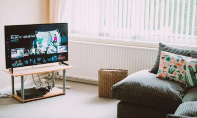 Persona midiendo el espacio para un televisor Sony Bravia 32 pulgadas: guía clara para elegir bien, con el televisor sobre un mueble en una sala pequeña