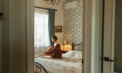 Persona usando un mando de aire acondicionado inteligente sin internet en un dormitorio moderno