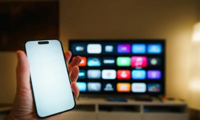 Persona usando un mando junto a un televisor inteligente para ilustrar cómo descargar magis tv en el televisor