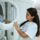 Lavadora y secadora modernas con panel digital y un smartphone sobre la encimera, imagen representativa de Samsung AI Laundry Combo: precio, funciones y ficha técnica en un lavadero luminoso