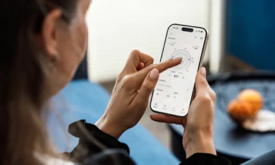 Persona controlando desde un smartphone varios electrodomesticos compatibles con matter en una cocina moderna