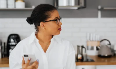 Persona controlando electrodomésticos inteligentes en una cocina moderna con un smartphone, ilustrando Electrodomésticos compatibles con Matter: guía para elegirlos