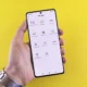 Persona en una cocina moderna usando un smartphone para controlar una nevera y un horno inteligentes, imagen para Electrodomésticos compatibles con Google Gemini: qué modelos ya apuntan al hogar