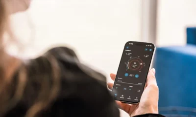 Persona mostrando en un smartphone la app Home Connect delante de una lavadora moderna — Cómo conectar una lavadora a Home Connect sin complicaciones