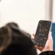 Persona mostrando en un smartphone la app Home Connect delante de una lavadora moderna — Cómo conectar una lavadora a Home Connect sin complicaciones