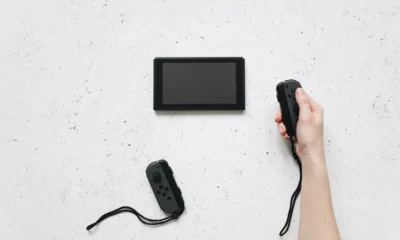 Manos conectando el dock de una Nintendo Switch al televisor en una sala de estar, imagen para ilustrar Cómo conectar Switch al televisor paso a paso y sin errores.