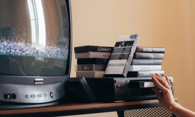 Persona desenchufando un decodificador frente a un televisor antiguo, ilustrando que Movistar Plus+ dejará de ser compatible con televisores antiguos pronto.