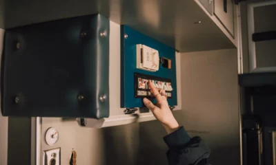 Persona cargando un lavavajillas moderno con la puerta abierta y ajustando el panel de control, imagen para el artículo Lavavajillas Candy Rapido: instrucciones en español y claves de uso