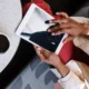 Persona consultando el Manual lavavajillas Bosch Silence Plus pdf: guía completa y segura en una tablet junto a un lavavajillas abierto en una cocina moderna.
