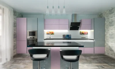 Placa de inducción con extractor incorporado: guía 2026 — vista de una isla de cocina moderna con placa de inducción negra, extractor retráctil levantado y una sartén mientras se cocina.