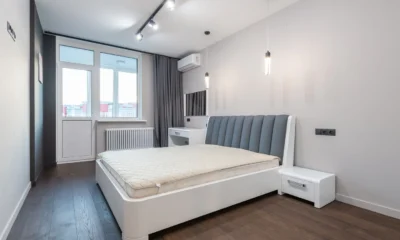 Un aire acondicionado portátil 12000 btu junto a la ventana de un dormitorio, con el tubo de evacuación instalado.