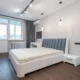 Foto de un aire acondicionado portátil junto a la ventana en un dormitorio moderno, ideal para ilustrar el artículo sobre cual es el mejor aire acondicionado portatil.