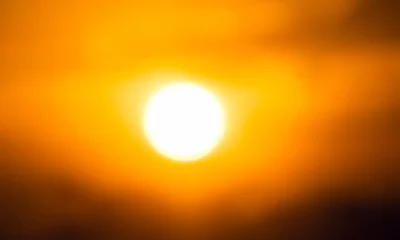 Primer plano de un control remoto de aire acondicionado con el icono de sol iluminado, ilustrando El símbolo del sol en el aire acondicionado: calor y uso correcto
