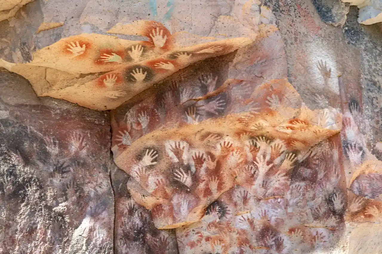 Primer plano de un manómetro de caldera con la aguja y la mano de un técnico ajustando una válvula, ilustrando Manómetro caldera: cómo leerlo, fallos y repuestos.