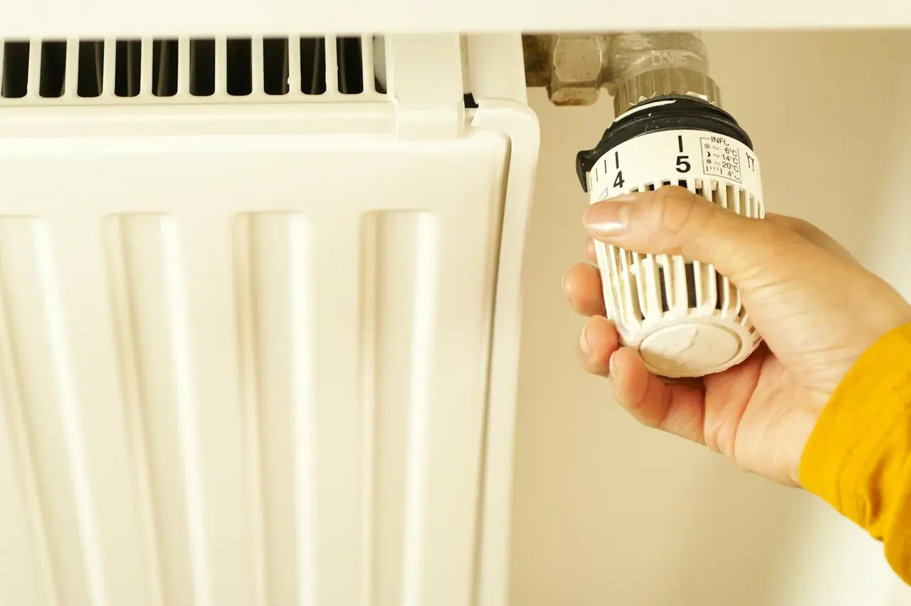Fotografía de un termostato programable en la pared, ideal para ilustrar ahorrar energía calefacción en el hogar.