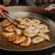 Primer plano de rebanadas doradas en una sartén mientras una persona las tuesta en la cocina — Como tostar pan sin tostadora: métodos, tiempos y trucos