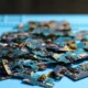 Granza de plástico reciclado junto a piezas desmontadas de electrodomésticos con plastico reciclado