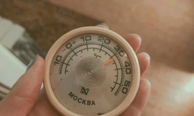 Termómetro junto a un frigorífico clase climática para ilustrar la temperatura ambiente y el rendimiento del electrodoméstico