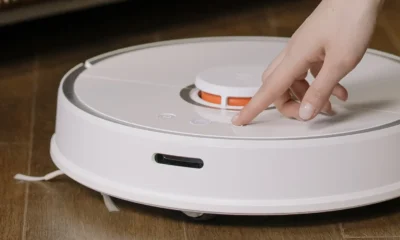 Robot aspirador blanco bajo un sofá, ideal para ilustrar el análisis del lefant m330 pro robot aspirador y su capacidad para limpiar debajo de los muebles.