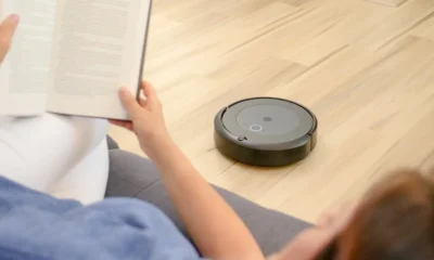 Robot aspirador con base de autovaciado: guía completa de compra — robot aspirador acoplado a su base de autovaciado en una sala de estar moderna junto a un sofá