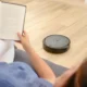Robot aspirador con base de autovaciado: guía completa de compra — robot aspirador acoplado a su base de autovaciado en una sala de estar moderna junto a un sofá