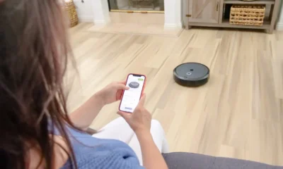 Robot aspirador y fregasuelos lidl en un salón moderno, con base de carga y control desde el móvil