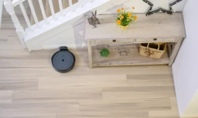 Robot aspirador iRobot Roomba 105 Combo: análisis completo — Roomba 105 en acción limpiando el suelo de una sala junto a un sofá, con la base de carga visible.