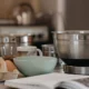Imagen de un robot de cocina compacto sobre una encimera moderna rodeado de ingredientes frescos, ilustrando el artículo Mambo 11090 de Cecotec: análisis del robot de cocina más compacto