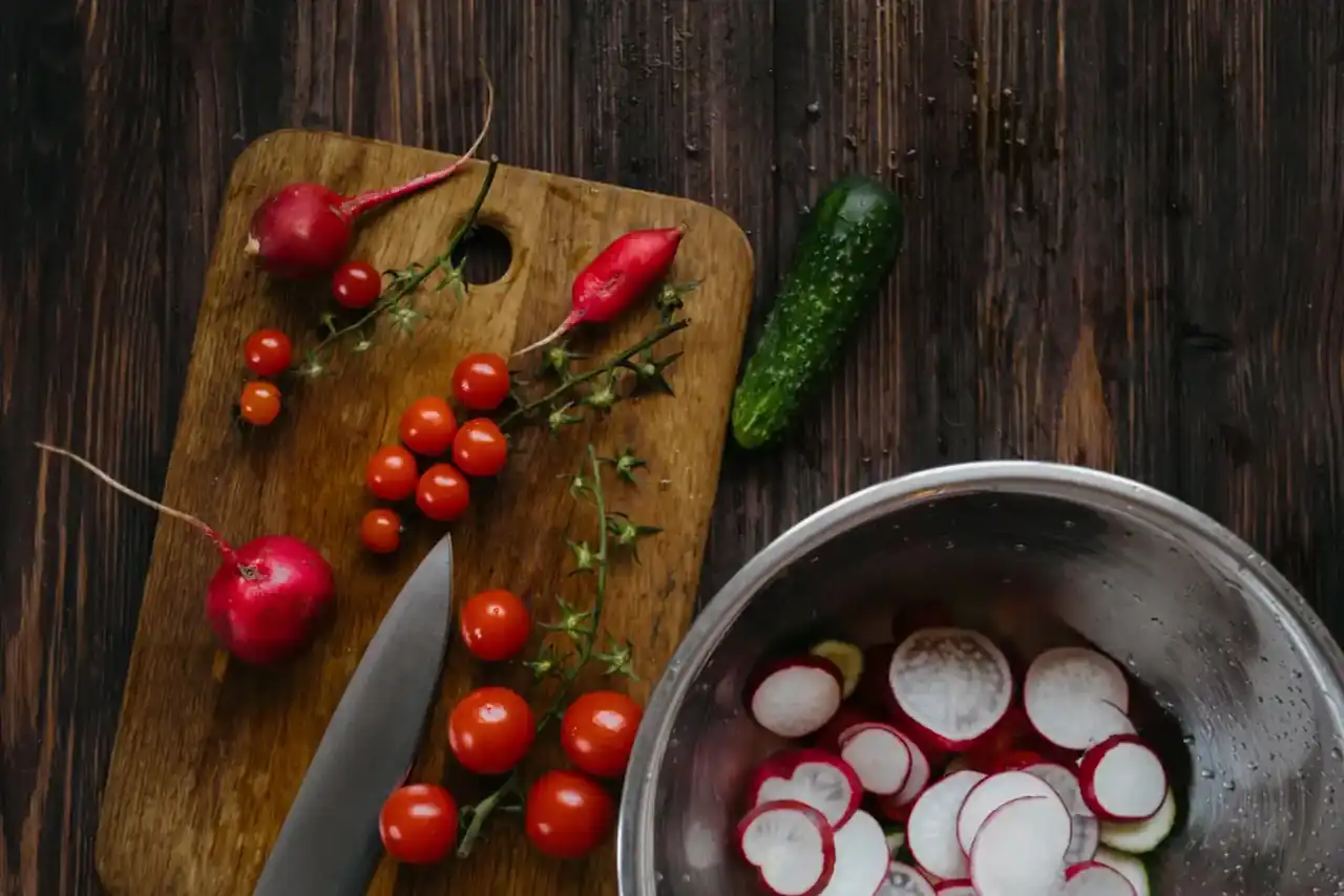 Robot de cocina de Aldi: precio, funciones y lo que ofrece — robot de cocina en una encimera con cuenco, ingredientes y folleto informativo mostrando sus funciones