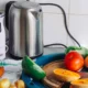 Robot de cocina multifunción en acción preparando una crema de calabaza sobre la encimera, ilustrando Qué hace un robot de cocina y para qué sirve de verdad.