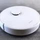 Robot aspirador Lidl a 59 euros: precio, funciones y claves — robot aspirador en un salón sobre suelo de madera con etiqueta de precio de 59€ junto a un mando y un smartphone.