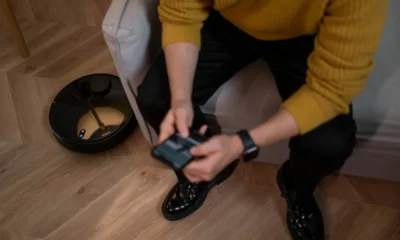 Robot aspirador con base de autovaciado en un salón moderno, junto a su estación de carga y vaciado automático.
