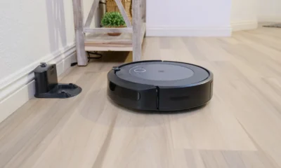 Robot aspirador autovaciado sin bolsa en un salón moderno junto a su base de carga
