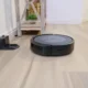 Robot aspirador autovaciado sin bolsa en un salón moderno junto a su base de carga
