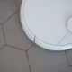 Aspirador robot con vapor limpiando el suelo de una cocina moderna