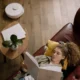 Imagen del Xiaomi Robot Vacuum S40: análisis, precio y rendimiento real — robot aspirador S40 limpiando un salón con suelo de madera junto a un sofá y un smartphone mostrando la aplicación de control.