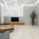 Sala de estar con televisor grande y cinta métrica en primer plano, ilustrando Cuanto mide un televisor de 75 pulgadas: medidas reales y espacio para mostrar dimensiones y espacio necesario