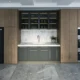 Cocina moderna con nevera y congelador vertical separados integrados junto a los muebles, mostrando una solución de almacenamiento amplia y ordenada.