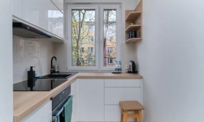 Cocina de un piso pequeño con electrodomesticos compactos para pisos pequeños y una persona cocinando
