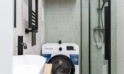 Mini lavadora con vapor en un rincón de apartamento pequeño, ideal para espacios reducidos.
