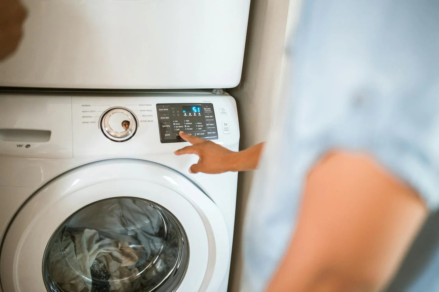 Lavadora conectada a enchufe inteligente en un hogar moderno, mostrando una solución de domótica para controlar el ciclo de lavado.