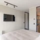 Televisor smart tv samsung 32 instalado en una pared de un dormitorio moderno y compacto