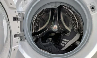 Zapatillas dentro de una secadora, ilustrando si se pueden meter las zapatillas en la secadora y los riesgos del calor sobre el calzado.