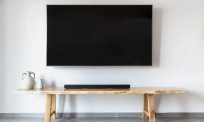Barra de sonido para televisor colocada bajo una televisión en un salón moderno